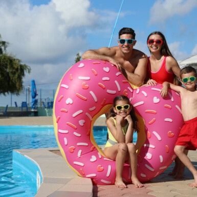 Happy family with inflatable ring near swimming pool.  Summer vacation